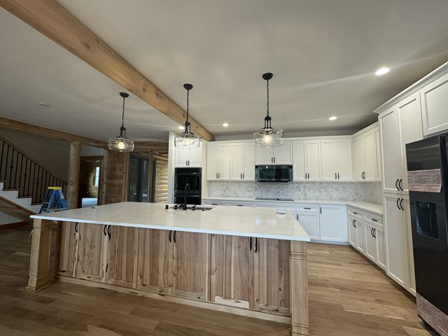 A kitchen with pendant lights hanging over the island