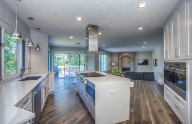 A kitchen island lit by recessed ceiling lights
