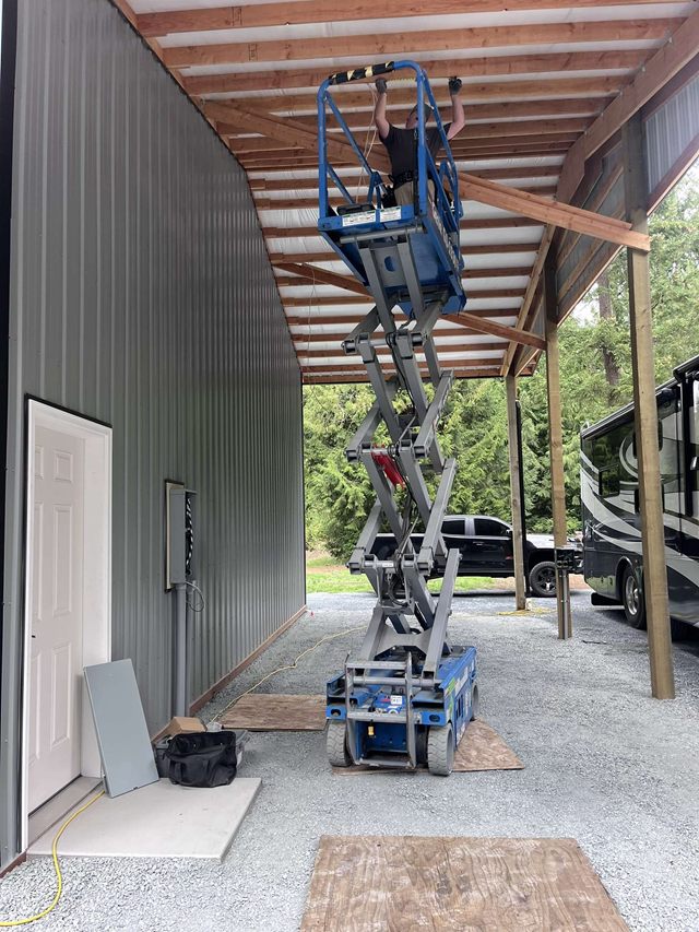 A scissor lift inside a shop fitted with high-bay lighting