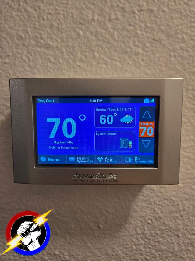 A smart thermostat mounted on a wall, reading 70 degrees